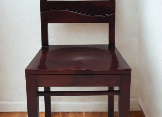 Solid wood dining chair with curved backrest and dark stain finish